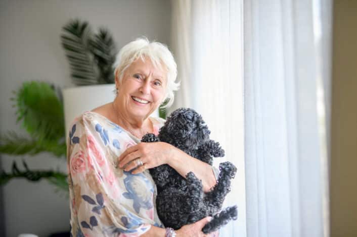 Senior qui tient dans ses bras un chien