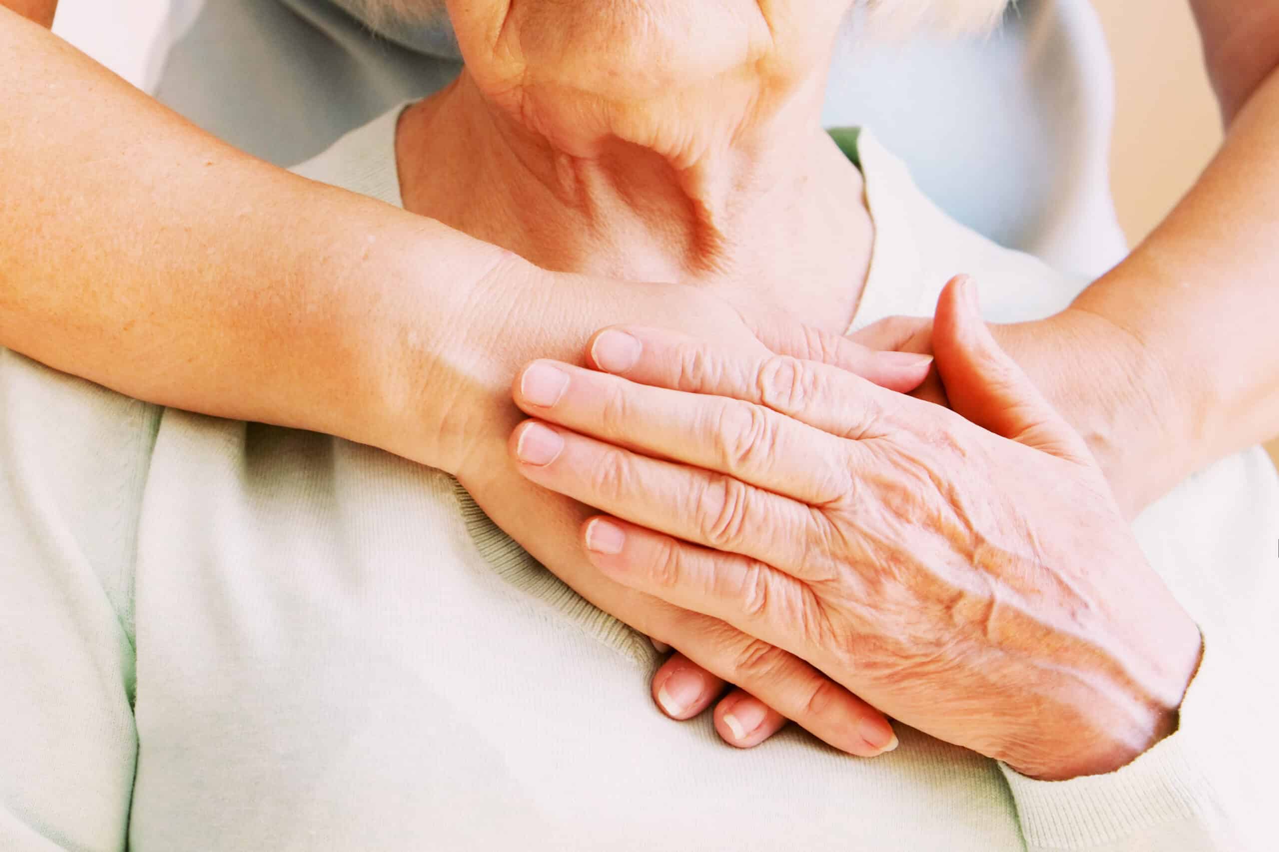 Mature female in elderly care facility gets help from hospital personnel nurse. Close up of aged wrinkled hands of senior woman. Grand mother everyday life. - Nohée