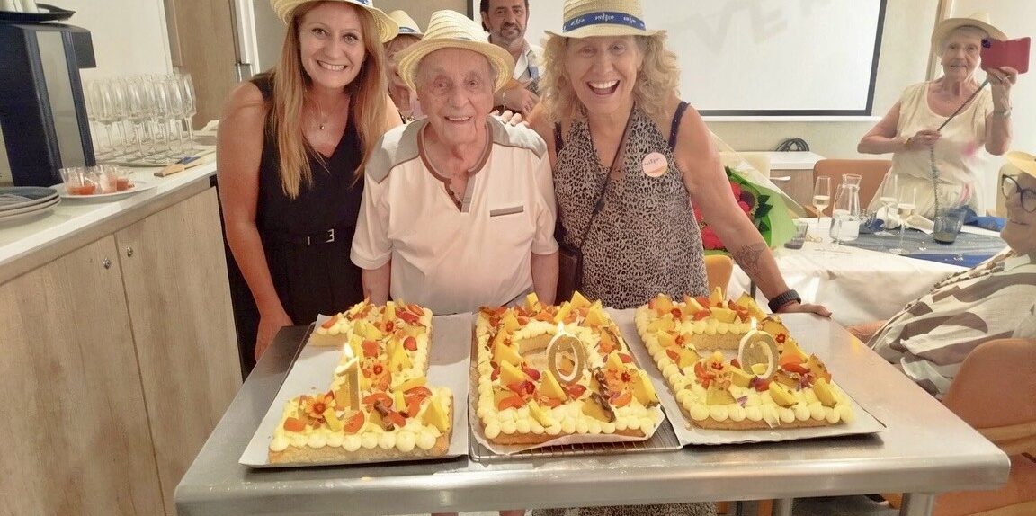 Des résidents et l'équipe de la résidence seniors Nohée devant un gateau 100 ans